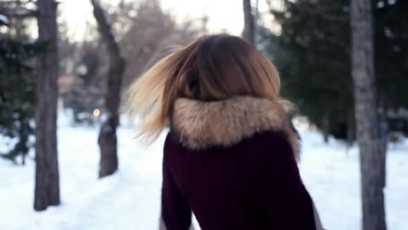 A Beautiful Girl Turns Around Herself Against the Backdrop of a Winter Forest