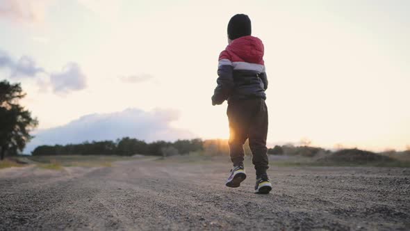 Cheerful Kid on the Road at Sunset