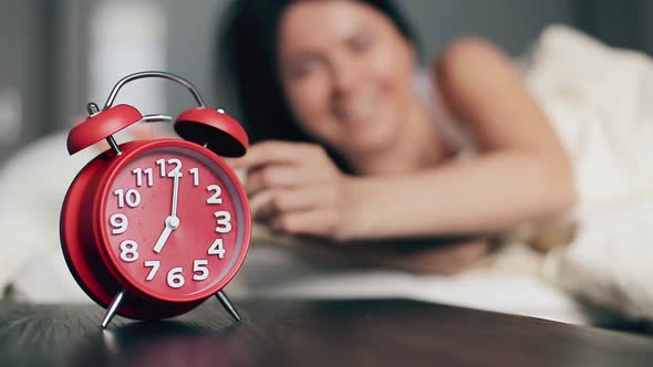 Woman Turning Off Alarm Clock Lying in Bed Morning Wake Up Happy Smile