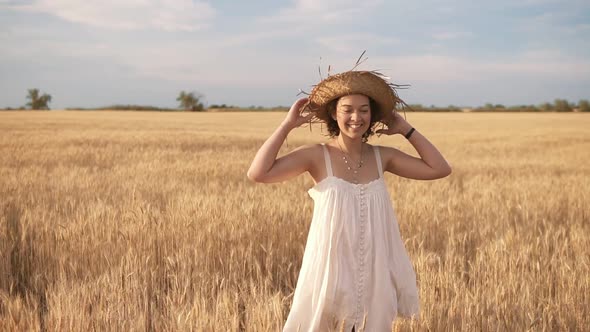 Beautiful Brunette Curly Lady in Wheat Field at Summer