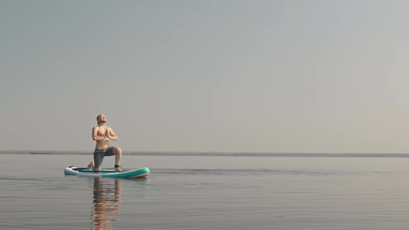 Man Practicing Yoga on Sup Board in Lake