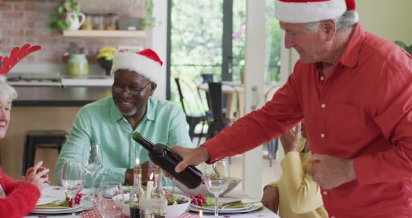 Happy group of diverse senior friends celebrating meal at christmas time