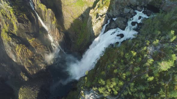 Voringfossen Waterfall and Cliffs with Green Trees in Norway at Sunny Summer Day. Aerial View