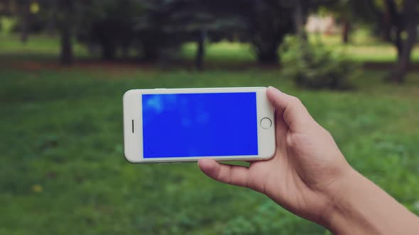 Blue Screen on the Phone Horizontally Holding Female Hand