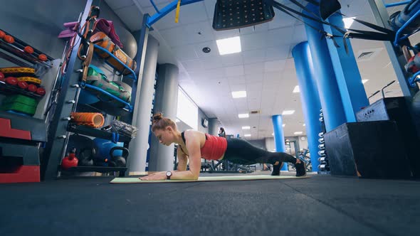 Woman training at fitness club. Shot of fitness woman on exercise mat