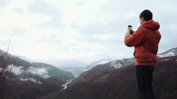 Tourist Taking Photos in Montains