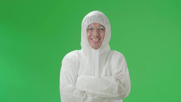 Male Wearing Personal Protective Equipment Uniform Ppe Pose With Arms Crossed In Green Screen Studio