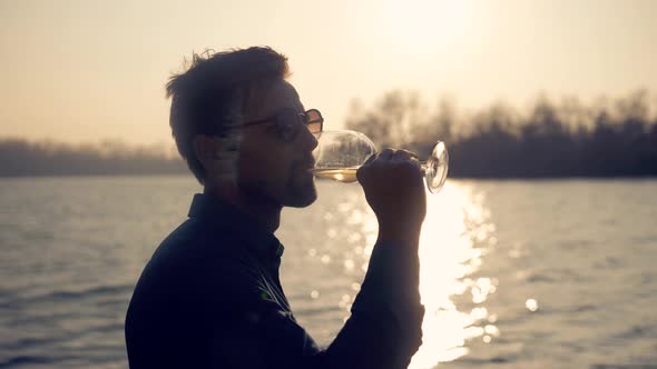 Man Drinking White Wine On Holidays Vacation. Romantic Evening Enjoying Wineglass.