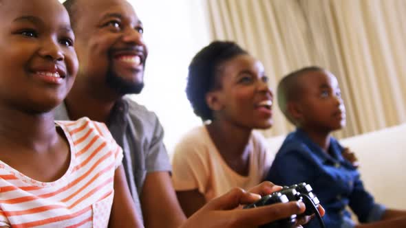 Parents and kids playing video games in living room