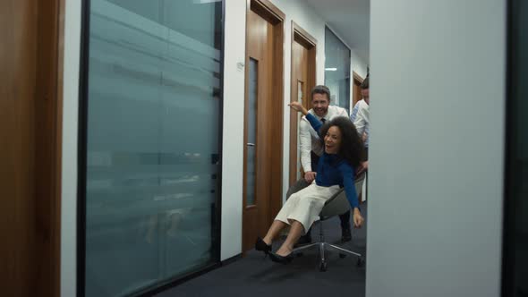 Happy Employees Group Celebrating Business Success Racing Office Chair Indoors