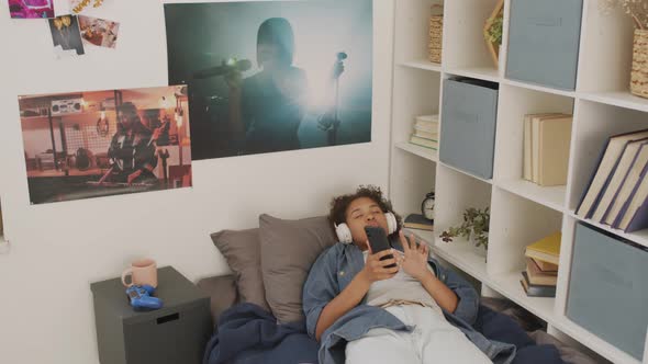 Young Adult Listening to Music in Bed