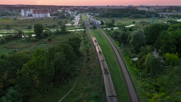 Passenger electric train rides by rail across the bridge from aerial view.