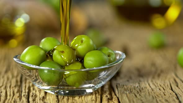 Super Slow Motion Shot of Pouring Fresh Olive Oil on Olives at 1000 Fps.