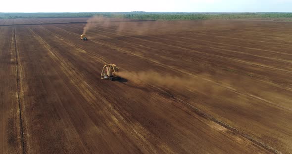 Peat Harvester Machines Collecting Peat Dust on Field Aerial View