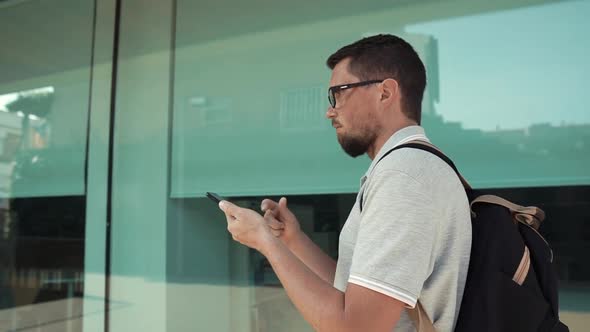 Male Tourist Is Walking Looking on Display of His Mobile Phone