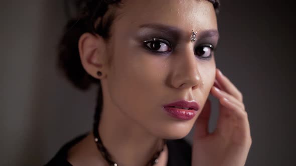 Young Beautiful Girl Posing in Front of the Camera. on the Face, Metal Jewelry.