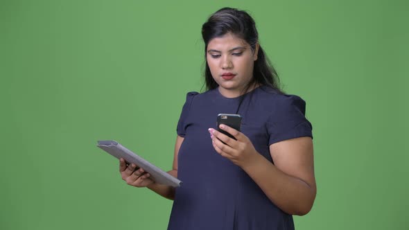 Young Overweight Beautiful Indian Businesswoman Against Green Background