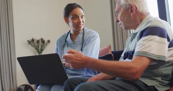 Animation of happy caucasian senior man talking with biracial female doctor using laptop