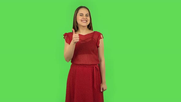 Tender Girl in Red Dress Is Showing Thumbs Up, Gesture Like. Green Screen