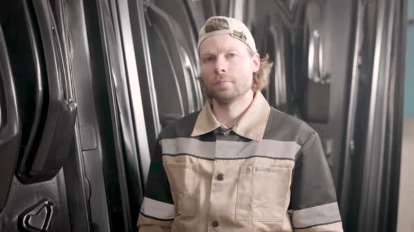 Male Worker at a Production Warehouse. Molded Bulk Plastic Parts