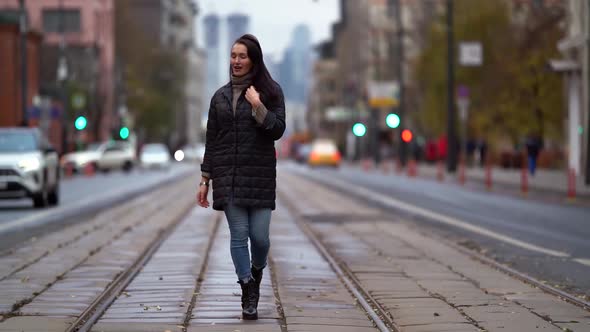 Happy Woman Is Enjoying Walk in City at Autumn Day, Strolling Over Tram Lines in Center of Road