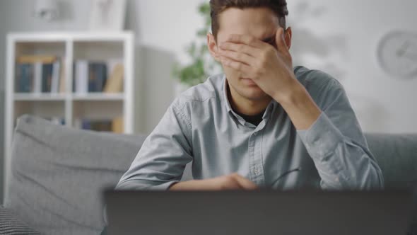 Man Feeling Tired After Work on Laptop