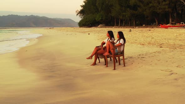 Beautiful women happy and smiling on exotic coast beach holiday by blue ocean with bright sand backg