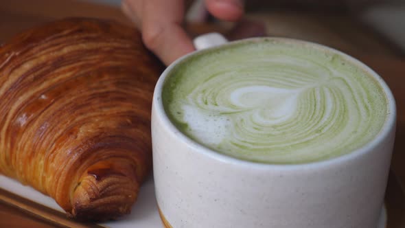 Mug of Matcha Tea Latte Served with Fresh Croissants