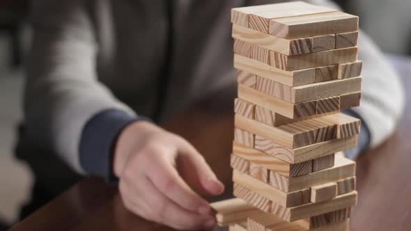 Boy and his mother play jenga. Close-up of the game with dice at home