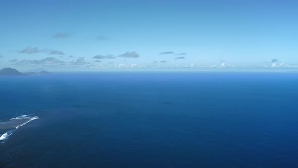 Aerial panorama of azure sea and shadow of the mountain in the distance in Saint Kitts and Nevis