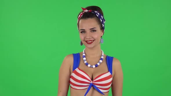 Portrait of Beautiful Girl in a Swimsuit Is Standing, Spreads Out in a Smile. Green Screen