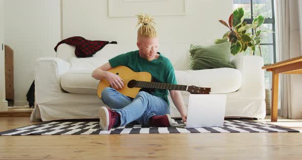 Albino african american man with dreadlocks playing guitars and singing