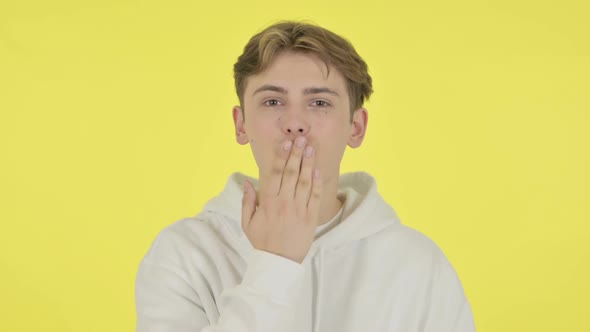 Flying Kiss By Young Man on Yellow Background