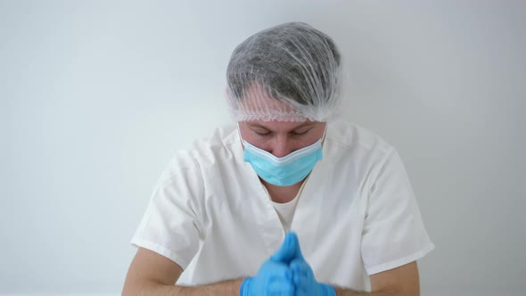 Portrait of Desperate Caucasian Doctor Praying Leaning on Wall in Hospital