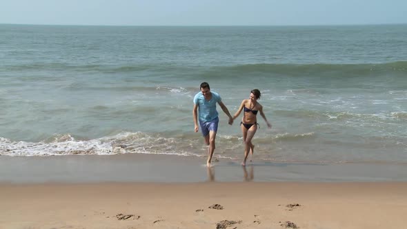 Couple running out from sea