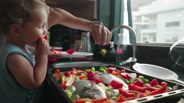 Mother Teaches Her Little Son How to Cook Healthy Food in the Kitchen