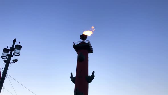 The flame flutters at the top of the rostral column at the blue sky background