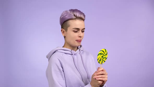 Young Woman in Purple Holding Lollipop Licking Lips Wanting Eat Candy