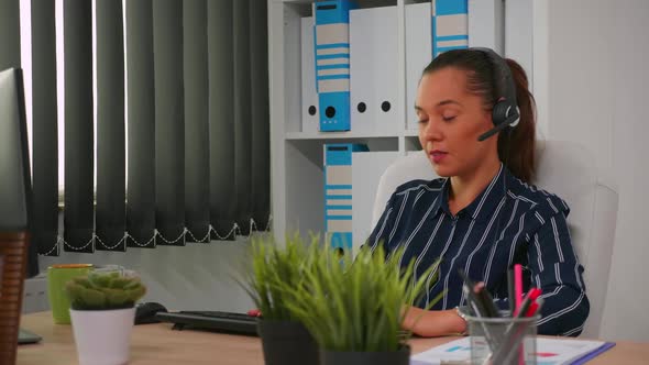 Hispanic Businesswoman with Headset Working in Modern Office