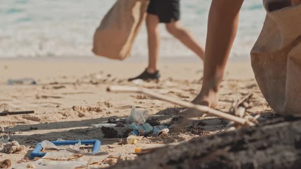 Volunteer Raises and Throws a Plastic Bottle Into the Garbage Eco Bag