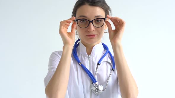 Female Doctor is Putting Off Protective Blue Gloves Isolated on White Background After Some Medical