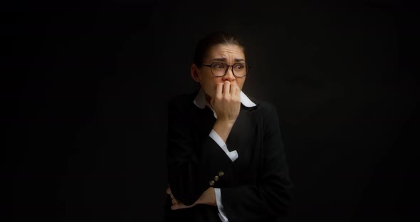 An Excited Young Business Woman with Glasses Biting Her Nails