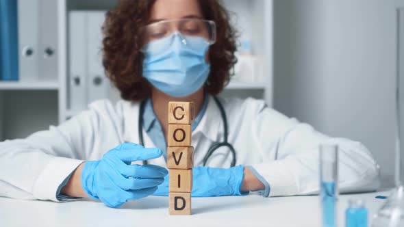 A Medical Doctor At A Working Table Shows The End Of The Pandemic In The Form Of The Letters