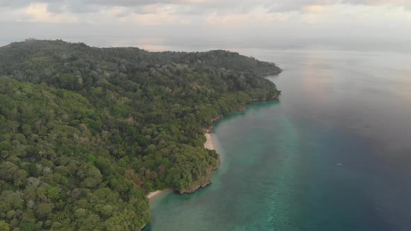 Aerial: flying over tropical Hatta island white sand beach Banda Islands Maluku