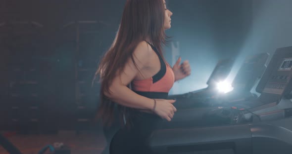 Side View of Young Attractive Pretty Woman in Sportswear Running on Treadmill at Gym Slow Motion