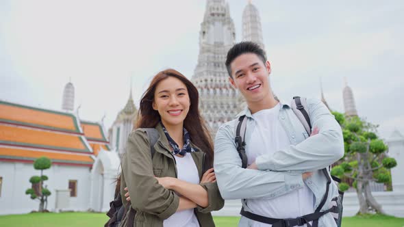 Portrait of Asian young couple travel in the city for holiday honeymoon trip and look at camera