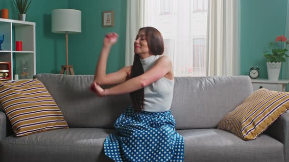 Woman Is Sitting On Sofa In Living Room and Dancing