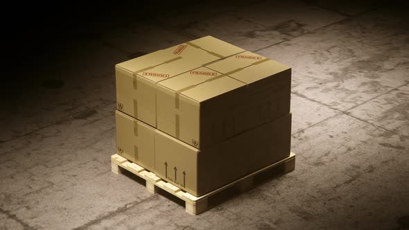 A stack of cardboard boxes on a pallet in the warehouse waiting for a forklift.