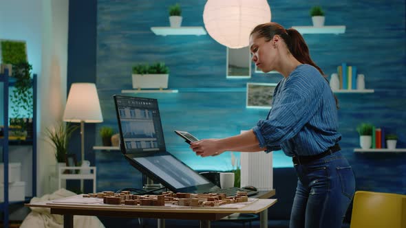 Woman Architect Analyzing Building Model on Tablet and Computer