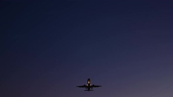 Airplane Flies Over The Camera At Dusk